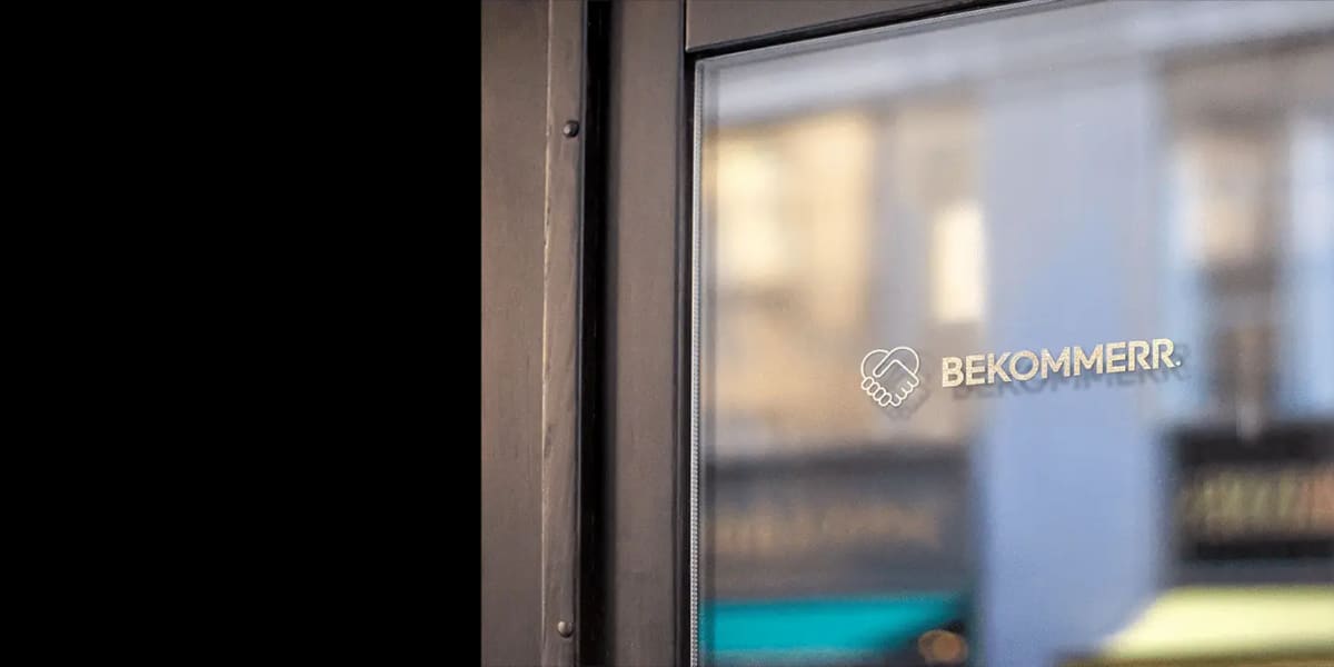 De gevel van het Bekommerr-kantoor met logo op het raam